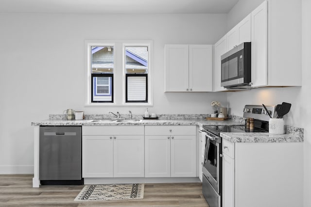 411 S Ferrall St, Spokane, WA 99202 - kitchen featuring appliances with stainless steel finishes, light wood-style floors, and white cabinetry