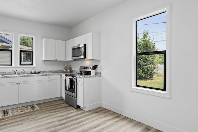 411 S Ferrall St, Spokane, WA 99202 - kitchen featuring appliances with stainless steel finishes, white cabinetry, and light wood-type flooring