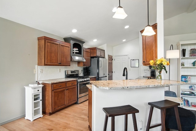 116 W Bristol Ave, Spokane, WA 99224 - kitchen with stainless steel gas range, freestanding refrigerator, vaulted ceiling, backsplash, and light wood-type flooring