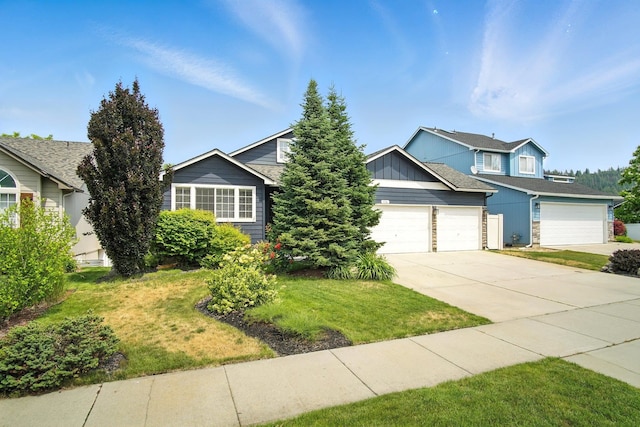 116 W Bristol Ave, Spokane, WA 99224 - view of front of home with concrete driveway, a front yard, an attached garage, and board and batten siding