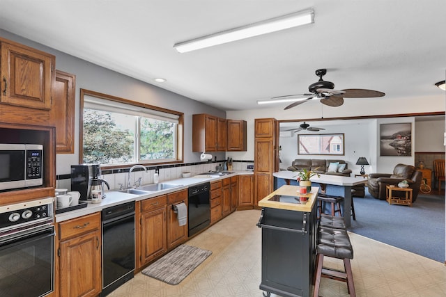 6519I Myrtle Dr, Nine Mile Falls, WA 99026 - kitchen featuring black appliances, light countertops, brown cabinetry, a breakfast bar, and light flooring
