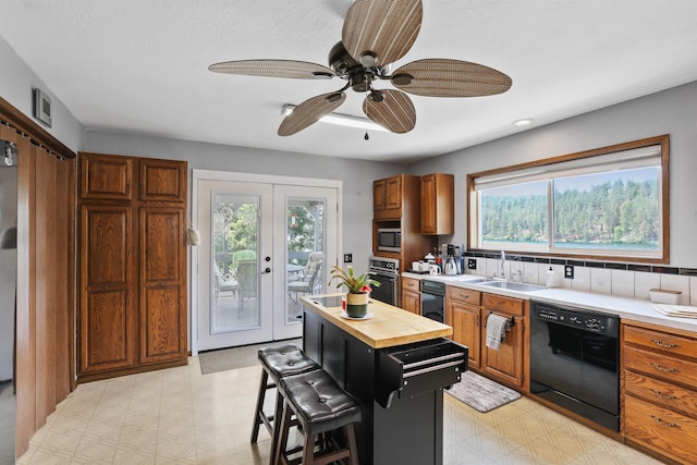 6519I Myrtle Dr, Nine Mile Falls, WA 99026 - kitchen featuring black appliances, light floors, wooden counters, and plenty of natural light