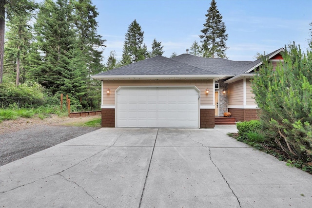 13306 N Muzzy Rd, Newman Lake, WA 99025 - view of front facade with concrete driveway, a shingled roof, and a garage