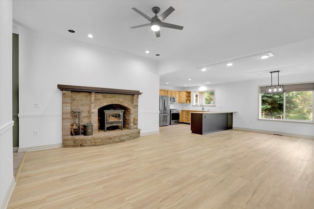13306 N Muzzy Rd, Newman Lake, WA 99025 - unfurnished living room featuring ceiling fan, light wood-style flooring, recessed lighting, and a wood stove