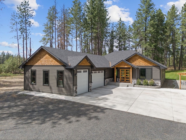 7617 S Cedar Rd, Spokane, WA 99224 - view of front of house featuring french doors, a garage, driveway, roof with shingles, and stone siding