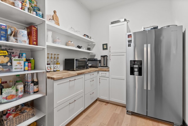 7617 S Cedar Rd, Spokane, WA 99224 - kitchen with stainless steel fridge, butcher block countertops, open shelves, light wood-style floors, and white cabinets
