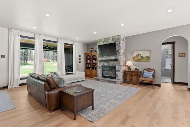 7617 S Cedar Rd, Spokane, WA 99224 - living room with arched walkways, a stone fireplace, light wood finished floors, and recessed lighting