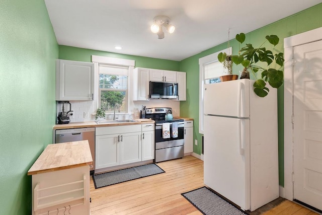 2103 W 5th Ave, Spokane, WA 99201 - kitchen with stainless steel appliances, wooden counters, white cabinets, and light wood-style flooring