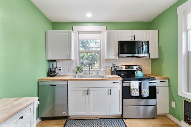 2103 W 5th Ave, Spokane, WA 99201 - kitchen featuring appliances with stainless steel finishes, tasteful backsplash, wood counters, white cabinets, and recessed lighting