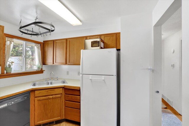 3511 W Francis Ave, Spokane, WA 99205 - kitchen featuring freestanding refrigerator, black dishwasher, light countertops, and brown cabinets