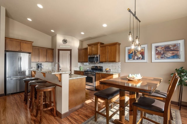 2820 S Galway Ln, Spokane Valley, WA 99037 - kitchen with appliances with stainless steel finishes, brown cabinets, decorative backsplash, dark wood-style floors, and recessed lighting