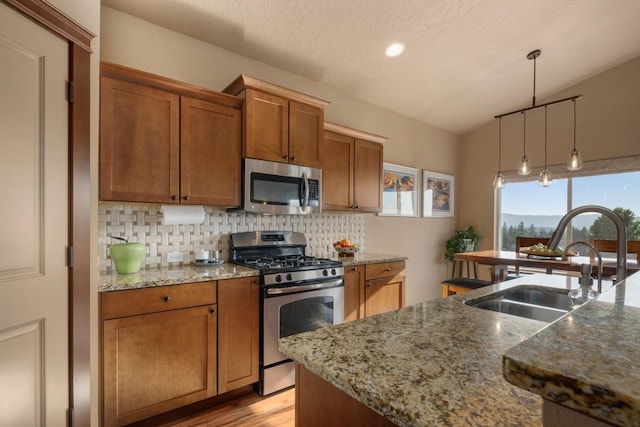 2820 S Galway Ln, Spokane Valley, WA 99037 - kitchen featuring appliances with stainless steel finishes, brown cabinetry, decorative backsplash, light wood-style floors, and recessed lighting