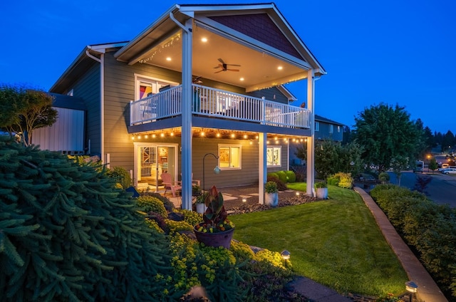 2820 S Galway Ln, Spokane Valley, WA 99037 - back of house at night with a balcony, a yard, and a ceiling fan