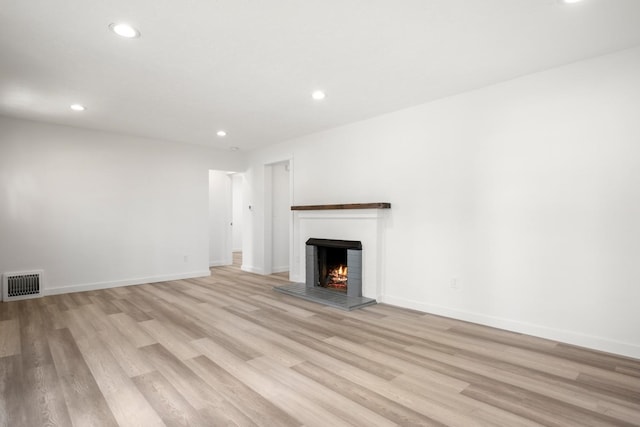 17 E 34th Ave, Spokane, WA 99203 - unfurnished living room with light wood finished floors, recessed lighting, and a warm lit fireplace