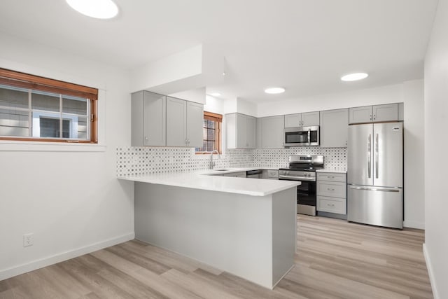 17 E 34th Ave, Spokane, WA 99203 - kitchen featuring stainless steel appliances, gray cabinetry, a peninsula, and tasteful backsplash