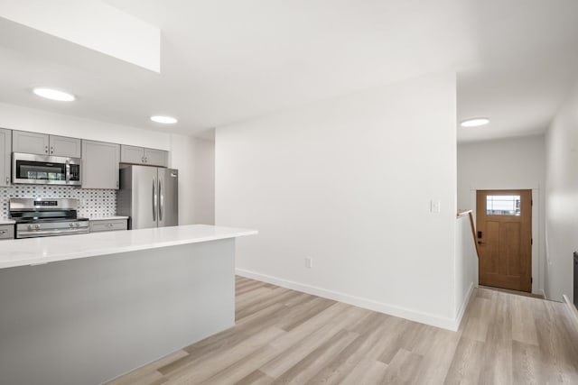 17 E 34th Ave, Spokane, WA 99203 - kitchen featuring appliances with stainless steel finishes, gray cabinets, light wood finished floors, and decorative backsplash