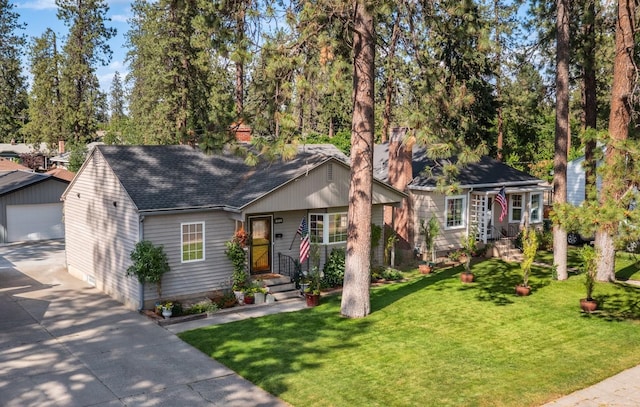 17 E 34th Ave, Spokane, WA 99203 - view of front of house with roof with shingles, an outbuilding, a detached garage, a front yard, and a chimney