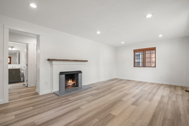 17 E 34th Ave, Spokane, WA 99203 - unfurnished living room with a lit fireplace, light wood-type flooring, and recessed lighting