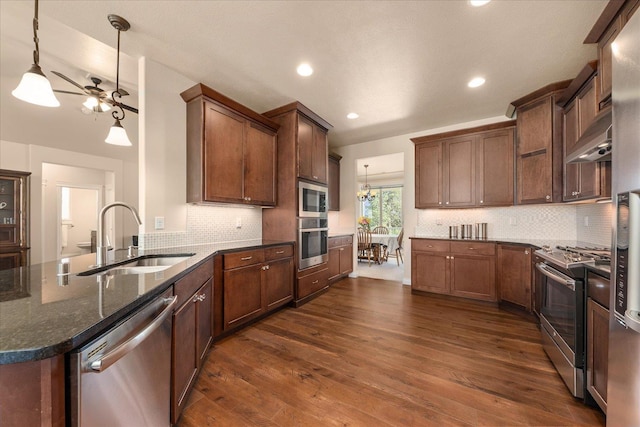 9302 W Floyd Dr, Cheney, WA 99004 - kitchen with stainless steel appliances, dark stone counters, backsplash, dark wood finished floors, and recessed lighting
