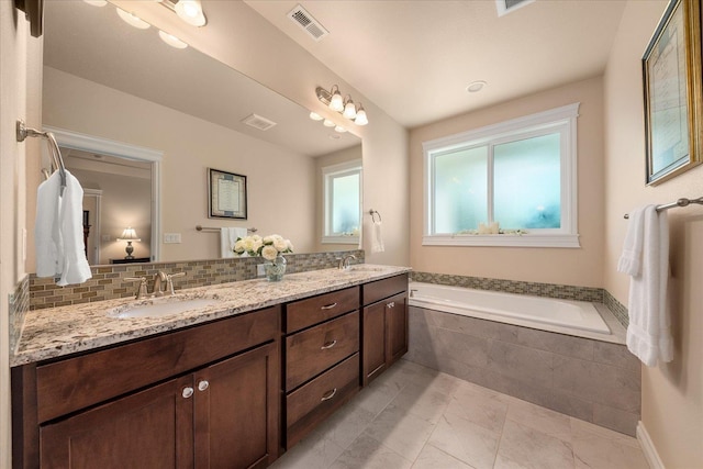 9302 W Floyd Dr, Cheney, WA 99004 - full bath with double vanity, a garden tub, backsplash, and marble finish floors