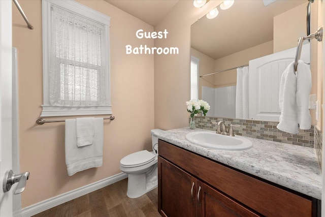 9302 W Floyd Dr, Cheney, WA 99004 - full bath with wood finished floors, vanity, tasteful backsplash, and curtained shower