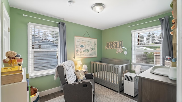 4204 W Olympic Ave, Spokane, WA 99205 - bedroom featuring wood finished floors, multiple windows, and a crib