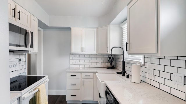4204 W Olympic Ave, Spokane, WA 99205 - kitchen featuring stainless steel microwave, white range with electric cooktop, white cabinets, tasteful backsplash, and light stone counters