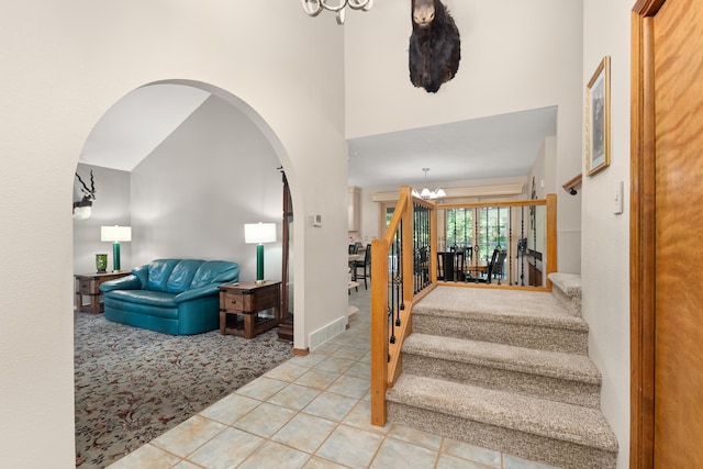 2913 E 61st Ct, Spokane, WA 99223 - stairs featuring a chandelier, arched walkways, a towering ceiling, and tile patterned floors