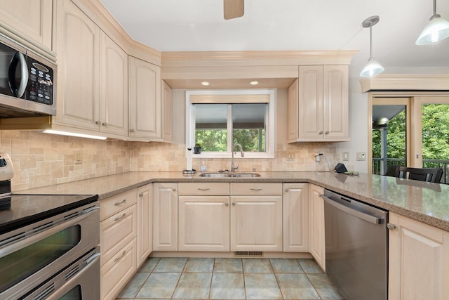 2913 E 61st Ct, Spokane, WA 99223 - kitchen with appliances with stainless steel finishes, decorative backsplash, decorative light fixtures, light stone counters, and light tile patterned floors