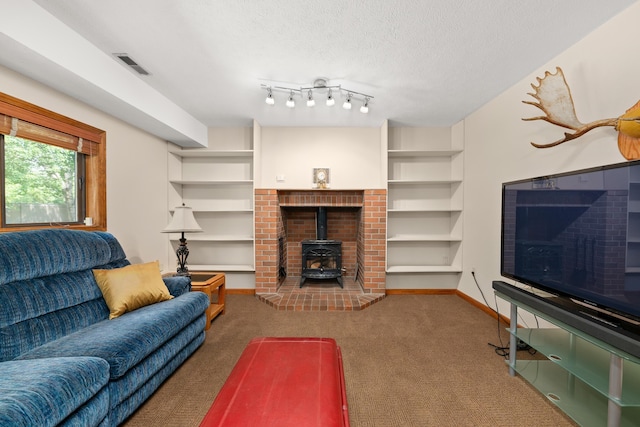 2913 E 61st Ct, Spokane, WA 99223 - carpeted living room featuring a wood stove, a textured ceiling, and built in shelves