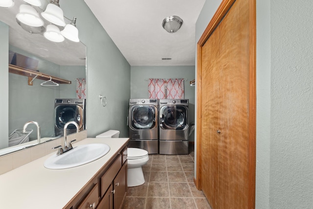 2913 E 61st Ct, Spokane, WA 99223 - bathroom featuring independent washer and dryer, vanity, and a textured wall