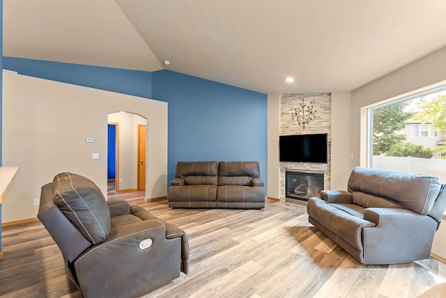 3518 S Woodlawn Dr, Spokane Valley, WA 99206 - living area featuring arched walkways, light wood-style flooring, lofted ceiling, a stone fireplace, and recessed lighting
