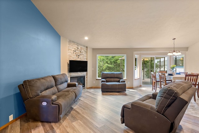 3518 S Woodlawn Dr, Spokane Valley, WA 99206 - living area with a chandelier, wood finished floors, vaulted ceiling, and a stone fireplace