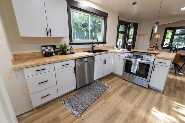 2514 4th Ave, Spokane, WA 99202 - kitchen with stainless steel appliances, butcher block counters, a peninsula, and white cabinets