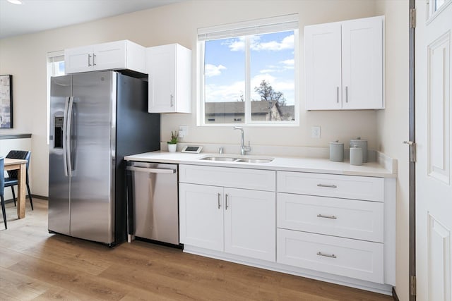 2519 N Columbus Rd, Spokane, WA 99207 - kitchen with appliances with stainless steel finishes, white cabinets, light wood finished floors, light countertops, and plenty of natural light