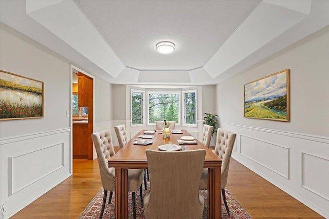 15116 N Edencrest Dr, Spokane, WA 99208 - dining space featuring a raised ceiling, wainscoting, wood finished floors, and a decorative wall