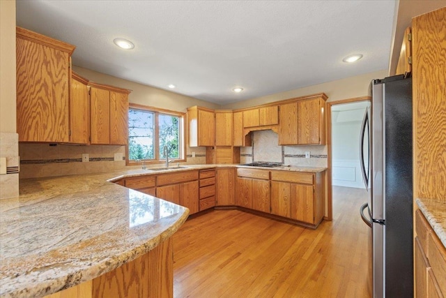 15116 N Edencrest Dr, Spokane, WA 99208 - kitchen with appliances with stainless steel finishes, light wood-style floors, tasteful backsplash, recessed lighting, and brown cabinetry