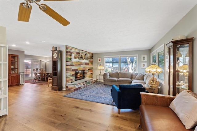 3410 S Napa St, Spokane, WA 99203 - living room featuring a textured ceiling, a ceiling fan, wood finished floors, a stone fireplace, and recessed lighting