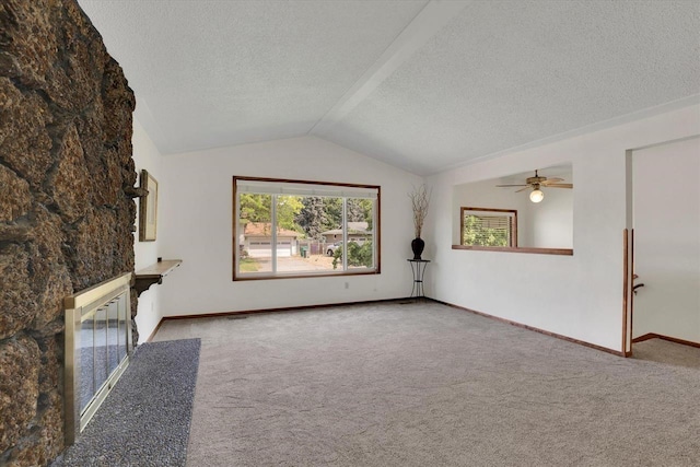 14417 N Dakota Rd, Spokane, WA 99208 - unfurnished living room featuring a fireplace with flush hearth, a textured ceiling, carpet, lofted ceiling, and a ceiling fan