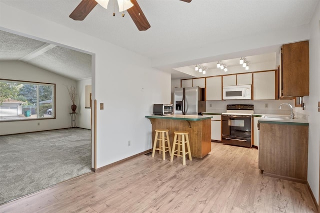 14417 N Dakota Rd, Spokane, WA 99208 - kitchen with range, white microwave, stainless steel refrigerator with ice dispenser, a peninsula, and ceiling fan