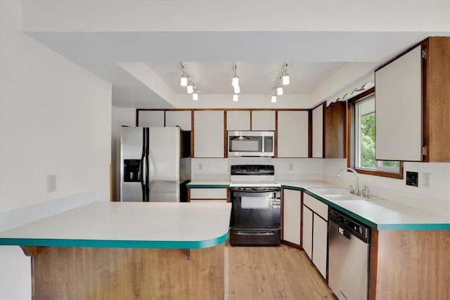 14417 N Dakota Rd, Spokane, WA 99208 - kitchen featuring appliances with stainless steel finishes, a peninsula, light countertops, and light wood-style flooring