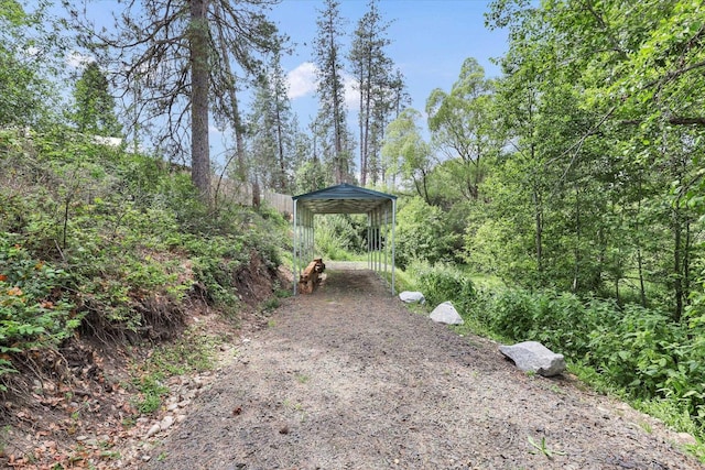 14417 N Dakota Rd, Spokane, WA 99208 - view of yard with dirt driveway, a carport, and a view of trees