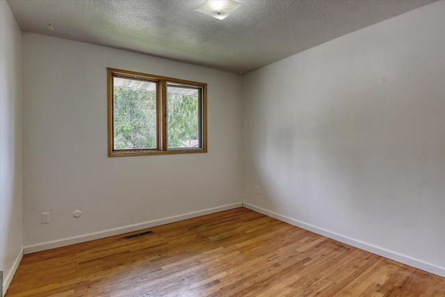 9405 N Normandie Ln, Spokane, WA 99218 - empty room featuring light wood finished floors and a textured ceiling