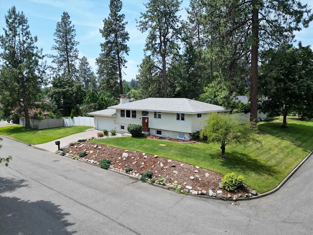 9405 N Normandie Ln, Spokane, WA 99218 - split foyer home with concrete driveway, an attached garage, and a chimney
