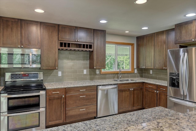9405 N Normandie Ln, Spokane, WA 99218 - kitchen featuring stainless steel appliances, light stone countertops, decorative backsplash, and recessed lighting