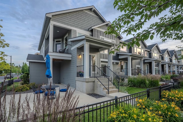 2303 W Bridge Ave, Spokane, WA 99201 - view of front facade with a balcony, a fenced backyard, and a patio area