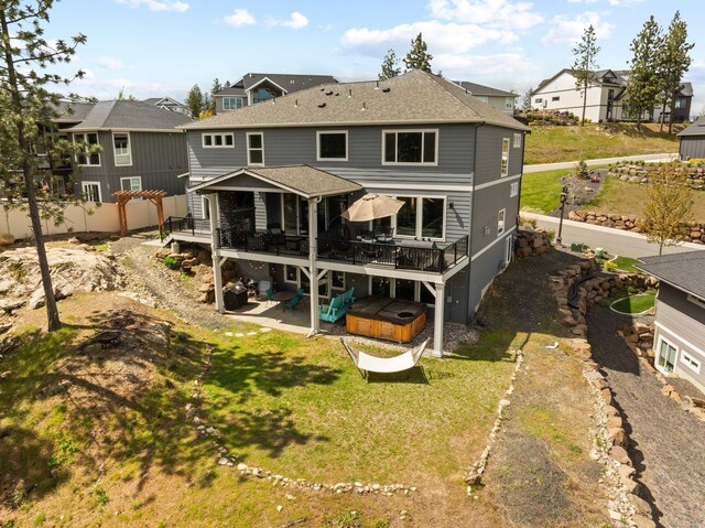 4513 S Crows Nest Ln, Spokane, WA 99206 - back of property featuring a hot tub, a deck, a patio area, and a yard