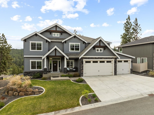 4513 S Crows Nest Ln, Spokane, WA 99206 - craftsman-style home featuring stone siding, a front lawn, concrete driveway, and an attached garage