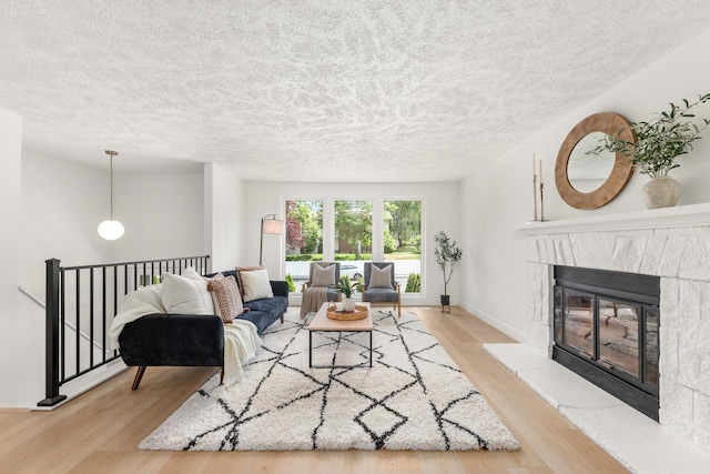 7721 N Wilding Dr, Spokane, WA 99208 - living area featuring wood finished floors, a textured ceiling, and a glass covered fireplace