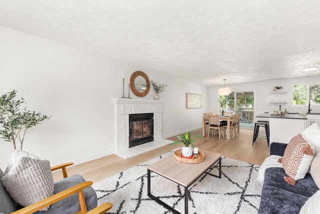 7721 N Wilding Dr, Spokane, WA 99208 - living area featuring light wood-type flooring, a tile fireplace, and a textured ceiling